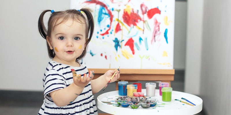 Eine Kunstwerkstatt in der Kita, Mädchen an einer Staffelei