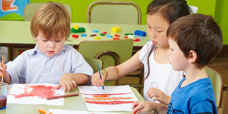 Malen mit Naturfarben, Kinder sitzen am Tisch und malen
