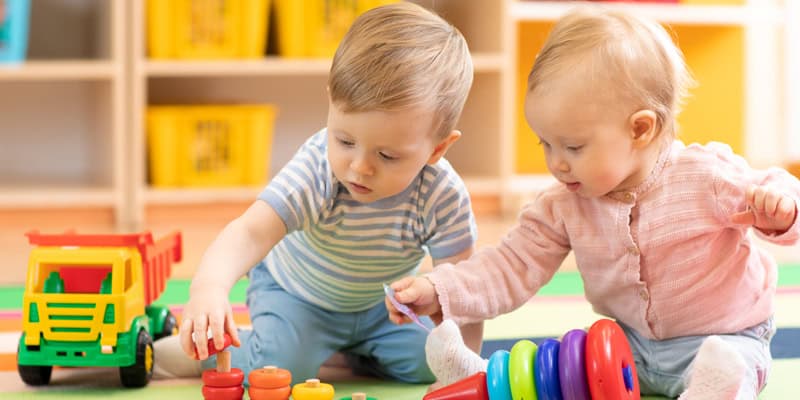 Alltagsintegrierte Sprachbildung in der Krippe, zwei Kleinkinder spielen gemeinsam