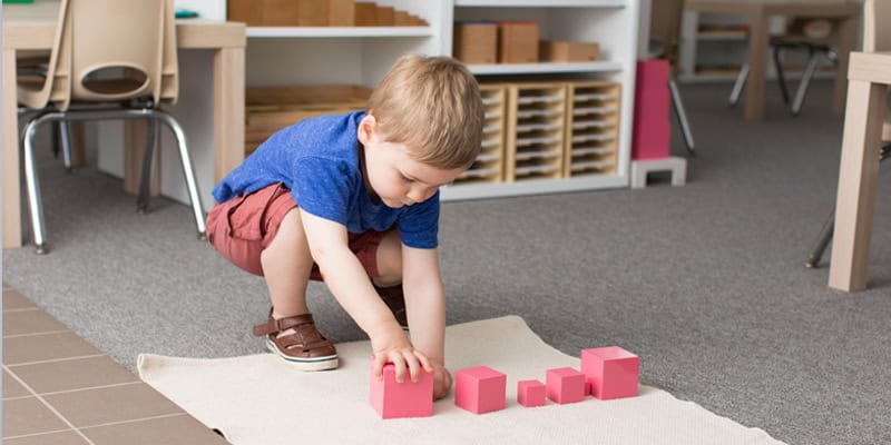 Junge baut rosa Turm