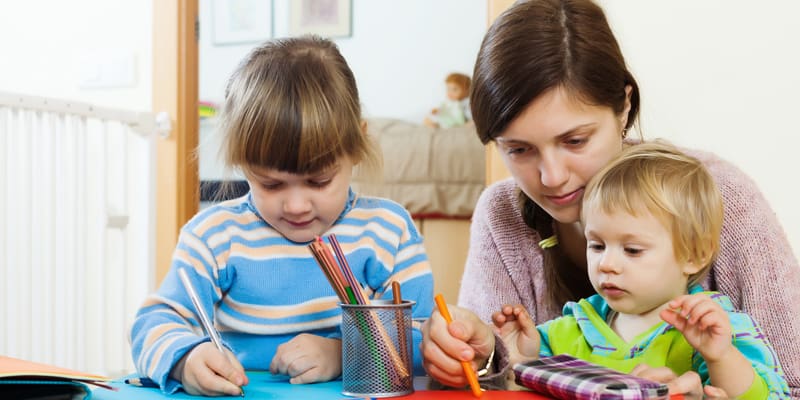Erzählen im Kita-Alltag, erzeiherin malt mit zwei Kindern