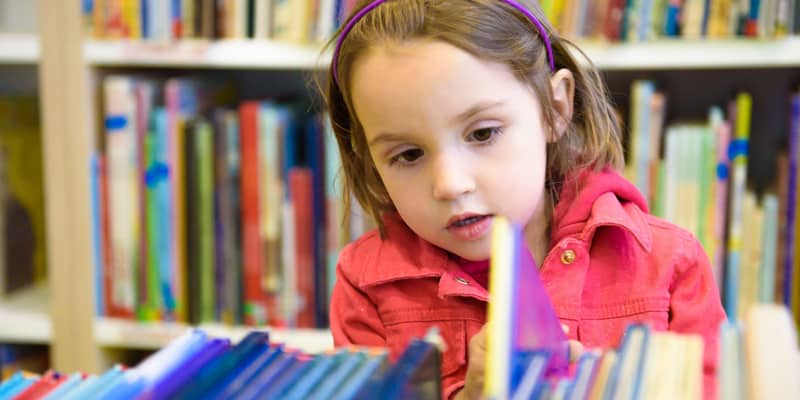 Lesen lernen vor der Schule? Mädchen in der Bücherei