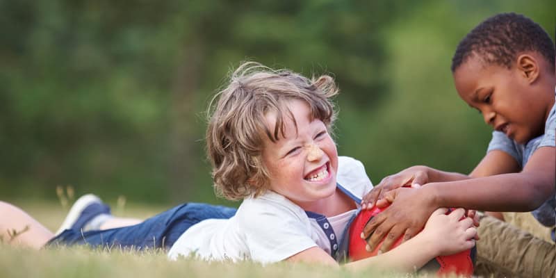 Ringen und Raufen nach Regeln, Kinder raufen um einen Ball